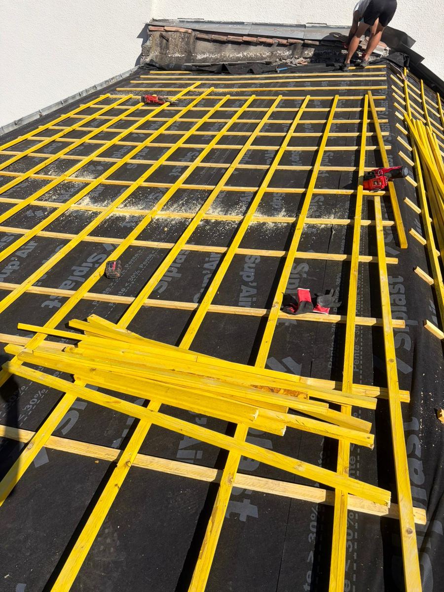 Contre-lattage et liteaux posés sur un écran de sous-toiture avant les tuiles, chantier d'isolation à Tautavel